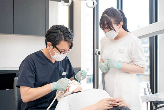 患者の歯の治療を行う歯科医師と歯科衛生士