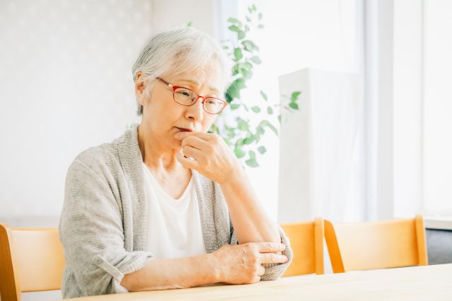 悩む高齢女性