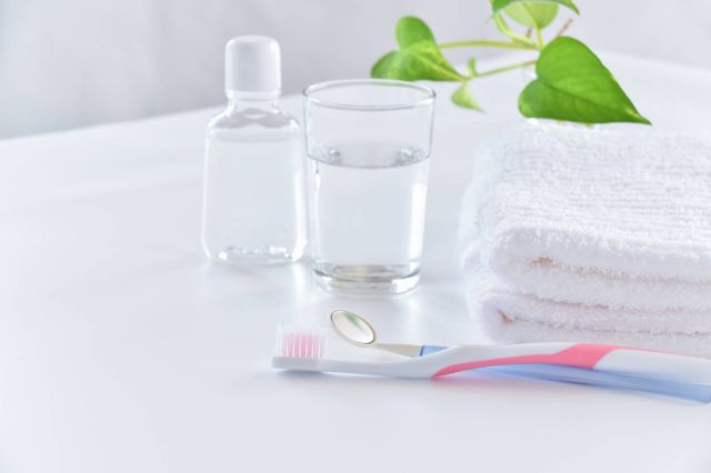 テーブルに置かれた歯ブラシ、タオル、コップ