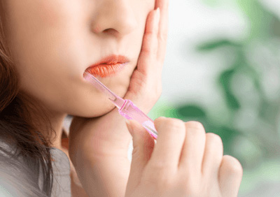 歯磨きをしながら頬を抑える女性