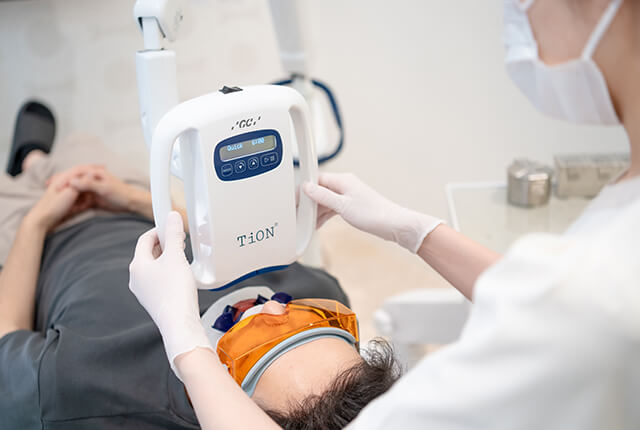 患者の歯のホワイトニングを行う歯科衛生士