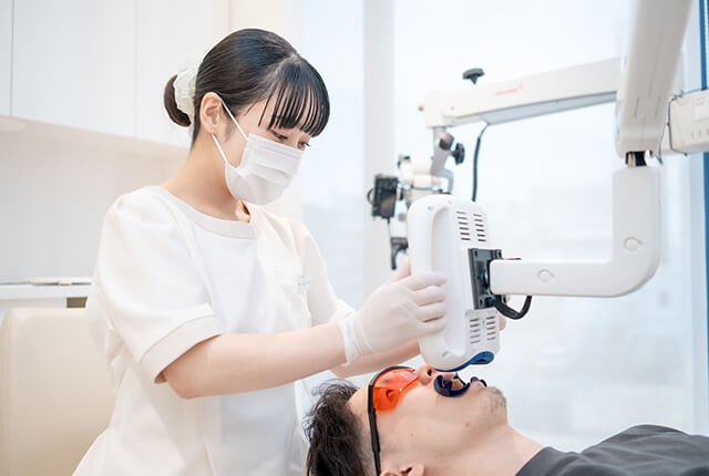 患者の歯のホワイトニングを行う歯科衛生士