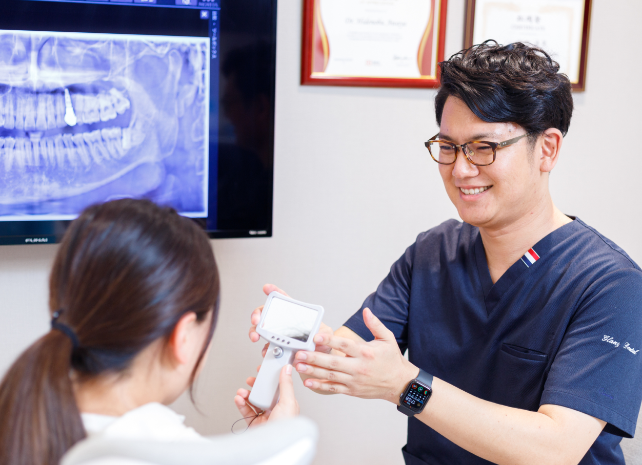 粟谷英信院長の患者さんと笑顔でカウンセリングする様子