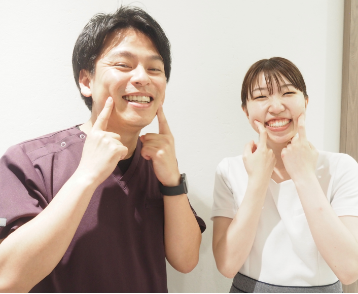 歯科医師西田卓矢先生と歯科衛生士がポーズをって笑う様子